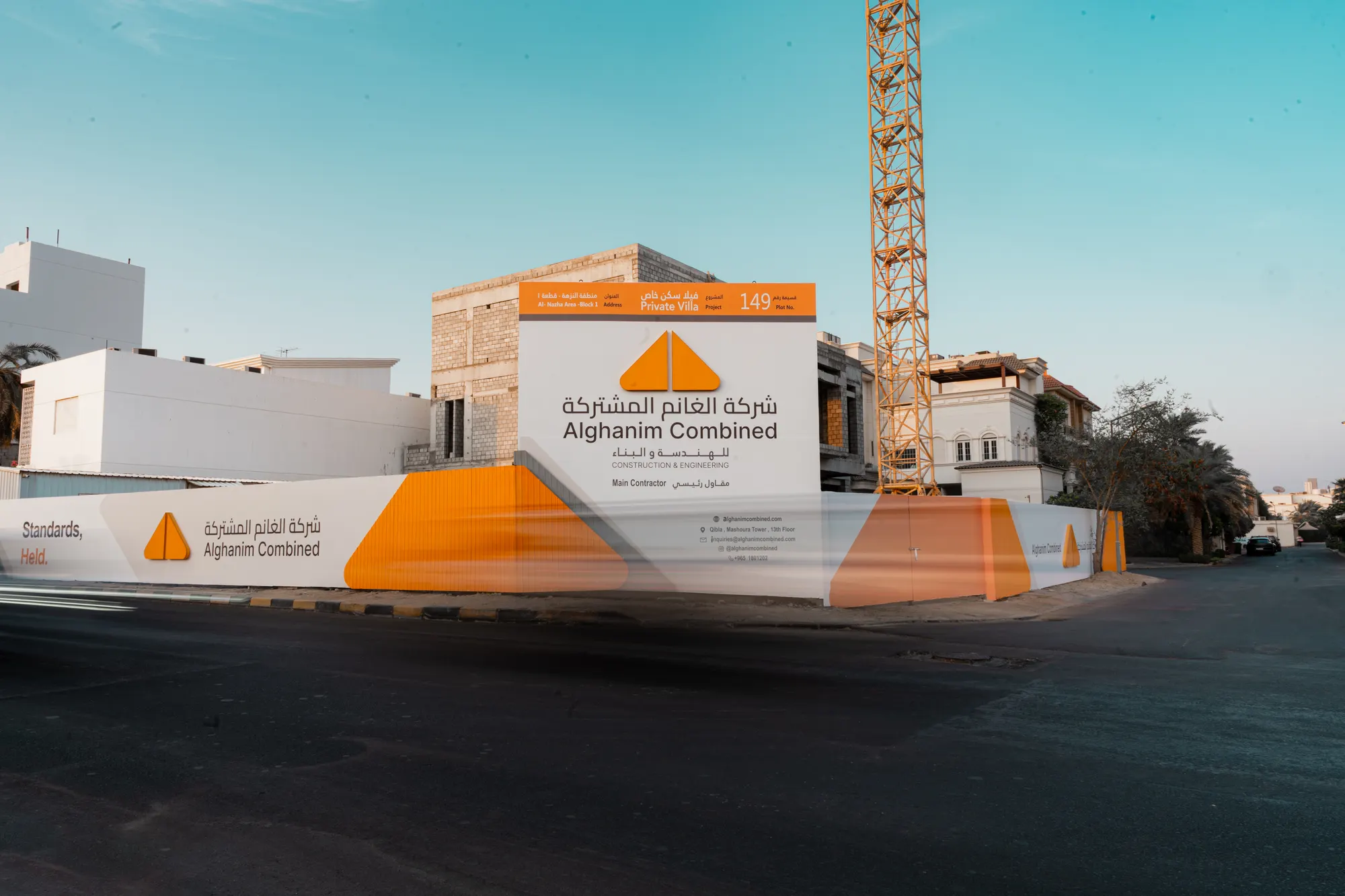 Alghanim Combined site hoarding and project sign at a villa under construction, with a tower crane behind